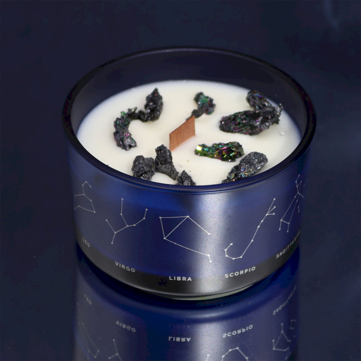 A softly flickering Zelyth Zodiac Crystal Candle, releasing a soothing aroma as the embedded crystals gradually emerge from the melted wax, creating a mesmerizing and celestial ambiance